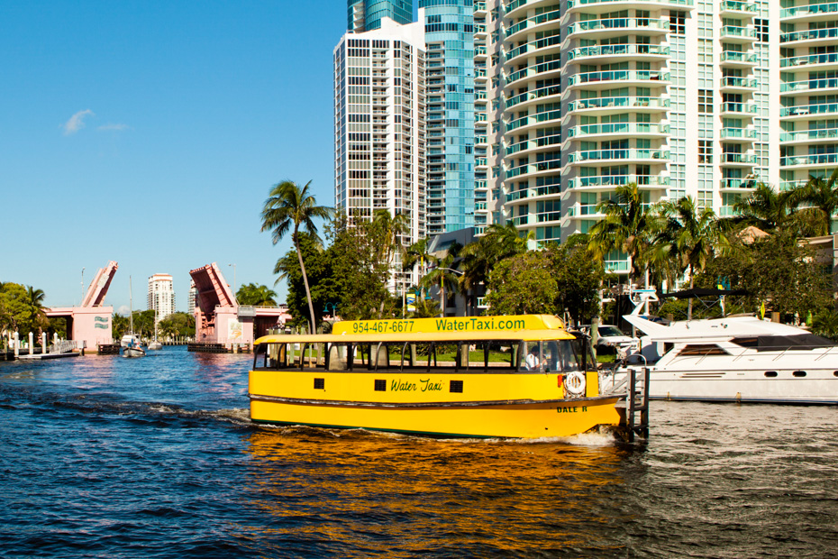 Tours in Miami Beach Florida to the Fort Lauderdale water taxi runs in the New River in Fort Lauderdale to connect to the Intracoastal Waterway. Water Taxis such as the one seen here are common and provide tours of the local landmarks and homes along the waterway.